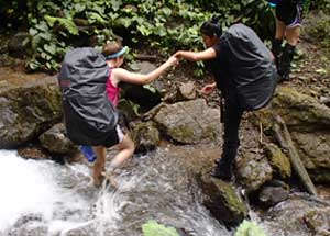 Amelia lends a hand to a Girl Scout while trekking the rainforest last summer.
