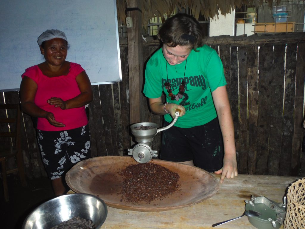 A girl making coffee with a local Tico