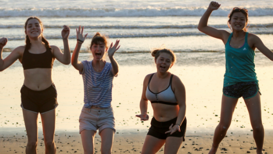 A group of Girl Scouts jumping for joy on the beach in Costa Rica